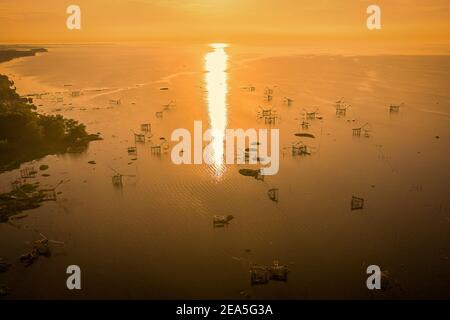 Traditionelle quadratische Netzgeräte bei Sonnenaufgang in Pakpra Canal, Phatthalung, Thailand Stockfoto