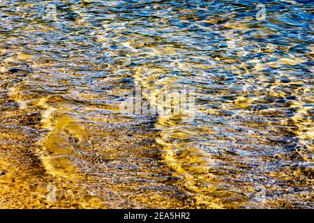 Goldene Wellen im Wasser am Tor 33 des Quabbin Reservoir, New Salem, Massachusetts Stockfoto