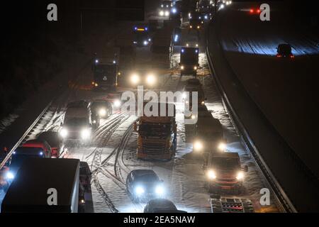 Dresden, Deutschland. Februar 2021, 08th. Auf der verschneiten Autobahn 4 bei Dresden stecken Autos und Lastwagen im Stau im frühen Morgenschnee fest. Quelle: Robert Michael/dpa-Zentralbild/dpa/Alamy Live News Stockfoto