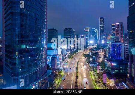 Luftaufnahme des Nachtverkehrs auf der Mehrspurbahn autobahn durch modernes Stadtzentrum mit Wolkenkratzern Innenstadt Jakarta Urban Stadtzentrum Stockfoto