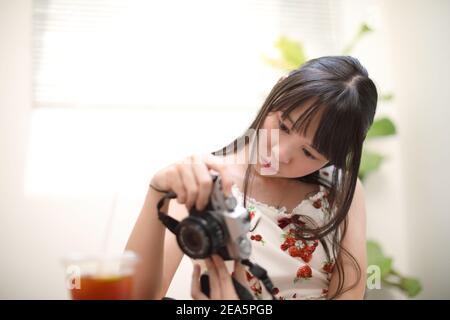 Porträt der asiatischen jungen Frau mit Kamera im Café Stockfoto