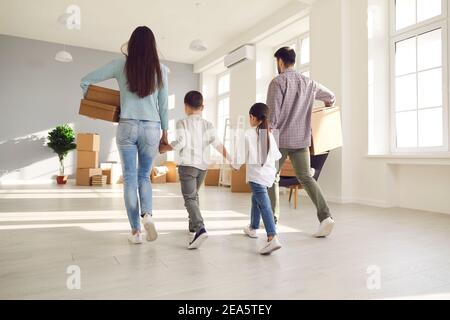 Familie trägt Pappkartons und gemeinsam in ihr neues Haus Am Umzugstag Stockfoto