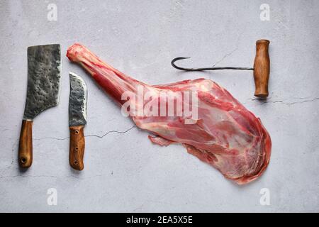 Blick von oben auf rohe frische Hirsch Bein mit Gewürz und Kraut über Beton Hintergrund Stockfoto