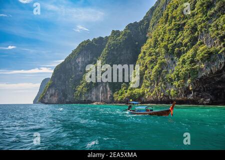 Blick auf die tropischen Inseln mit einem langen Boot und blauem Meerwasser auf den Phi Phi Inseln, Krabi Thailand Naturlandschaft Stockfoto