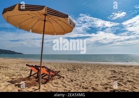 Strand Sommer Reise Urlaubskonzept mit Stuhl Sonnenschirm weißen Sand Strand blauer Himmel und Meer Wasser Ozean