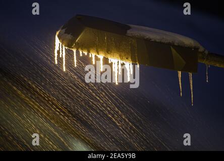 Dresden, Deutschland. Februar 2021, 08th. Eiszapfen hängen an einer Lampe am Dresdner Hauptbahnhof, wenn Schnee fällt. Quelle: Robert Michael/dpa-Zentralbild/dpa/Alamy Live News Stockfoto