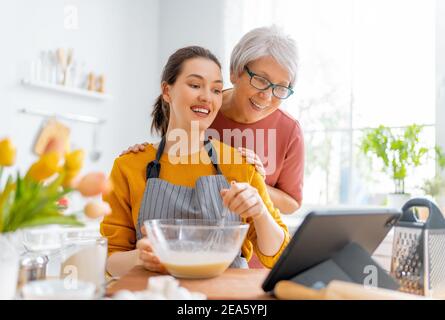 Gesunde Ernährung zu Hause. Glückliche Frauen bereiten Gebäck in der Küche zu. Stockfoto