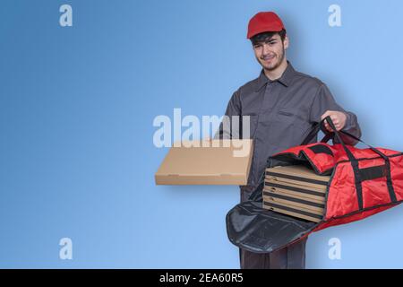 Fast-Food-Delivery-Mann mit Pizza-Boxen in den Händen liefern die Bestellung für die Lieferung, in Uniform gekleidet und lächelnd, mit roten Beutel und Kappe Stockfoto