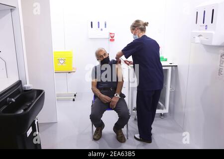 Olivia Smart, fortgeschrittener Praktiker und Verteidiger des Leeds Ladies FC, impft Mewa Singh Khela, 72, mit seiner ersten Dosis des Coronavirus-Impfstoffs Oxford/AstraZeneca im Elland Road Impfzentrum in Leeds. Bilddatum: Montag, 8. Februar 2021. Stockfoto