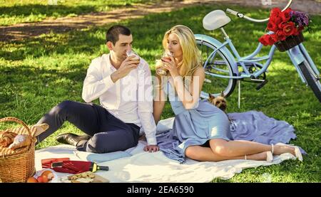 Express Positivität. Genießen Sie die Natur zusammen. Mit Picknick im Stadtpark. Mann und Frau entspannen mit Esskorb. Romantische Reisende Paar beobachten schöne Landschaft. Paar in der Liebe auf grünem Gras. Stockfoto