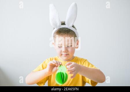 Kleiner Junge hält Bunny für Ostern Grußkarte. Kinderkunstprojekt. DIY-Konzept Stockfoto