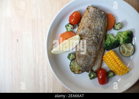 Seebarsch Filet , gebackenen Seebarsch mit Zitronensauce auf Holz Hintergrund Stockfoto