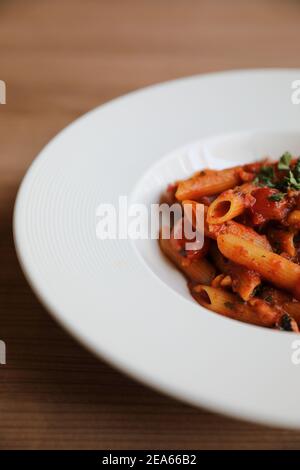 Penne arrabiata Pasta Tomatensauce mit Gewürzen italienische Küche auf Holzhintergrund Stockfoto