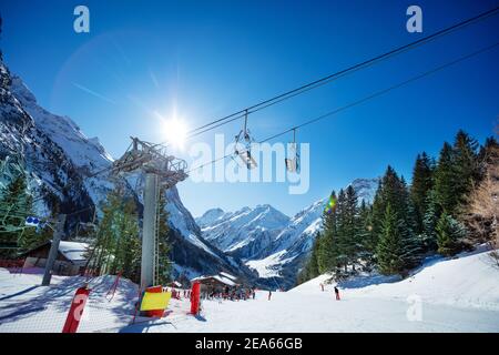 Bergskiweg am sonnigen Tag in sonnenbeschienenen mit französischen Alpen Berge, Skilift und Stühle im Vordergrund Stockfoto