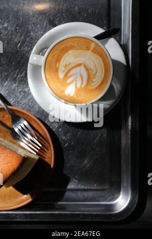 Heißer Cappuccino oder Latte Art Kaffee aus Milch auf Der Holztisch im Café Stockfoto