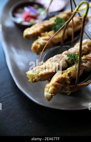 Chicken Satay auf dunkelbraunem Tisch Street Food Vorspeise Stockfoto