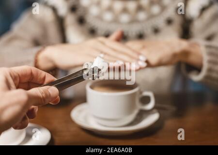 Eine Frau in einem Café lehnt ein Stück weißen Zucker für ihren Tee ab. Sagen Sie Nein zu Zucker und schnelle Kohlenhydrate. Diät für Diabetes und sucht nach süßen Junk-Food Stockfoto