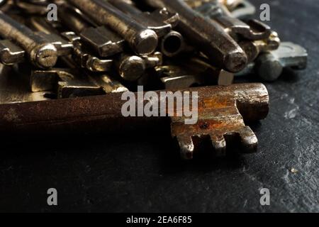 Nahaufnahme des alten rostigen Metallschlüssels und Hintergrund von Schlüsseln. Stockfoto