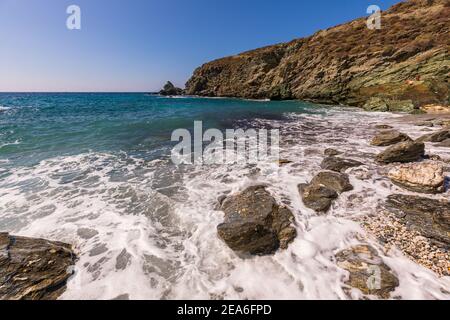 Insel Folegandros, Griechenland - 25. September 2020: Blick auf die Küste und den felsigen Ampeli Strand der Insel Folegandros. Die Leute sonnen sich auf dem Be Stockfoto