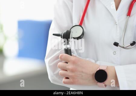 Otorhinolaryngologe hält Otoskop in den Händen in der Klinik Nahaufnahme Stockfoto