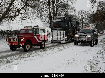 Uppingham, Rutland, Großbritannien. 8th. Februar 2021. Wetter in Großbritannien. Ein Fahrer aus Leicestershire und Rutland 4x4 Response zieht einen gestrandeten Lastwagen auf einem Schnee- und eisbedeckten Hügel hinauf. Credit Darren Staples/Alamy Live News. Stockfoto