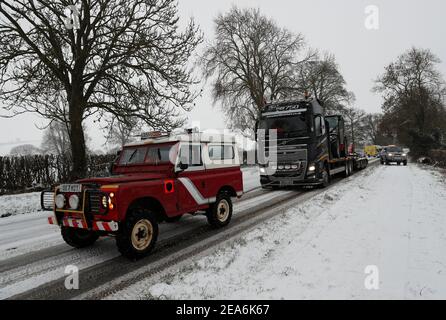 Uppingham, Rutland, Großbritannien. 8th. Februar 2021. Wetter in Großbritannien. Ein Fahrer aus Leicestershire und Rutland 4x4 Response zieht einen gestrandeten Lastwagen auf einem Schnee- und eisbedeckten Hügel hinauf. Credit Darren Staples/Alamy Live News. Stockfoto