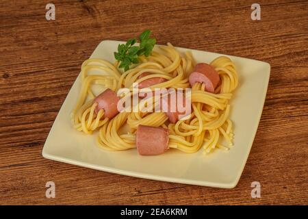 Kinder Pasta Spaghetti mit Würstchen und Basilikum Stockfoto