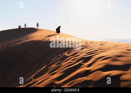 10. September 2020, Patara, Türkei: Touristen wandern bei Sonnenuntergang am Rande einer riesigen Sanddüne in Patara entlang. Natürliche Sehenswürdigkeiten in der Türkei Stockfoto