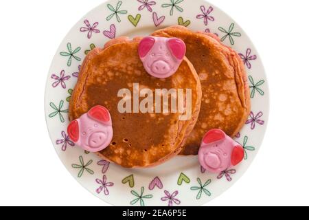 Percy Pig Pfannkuchen von M&S auf Teller mit Percy Pig Süßigkeiten bereit für den Valentinstag auf weißem Hintergrund gesetzt Stockfoto