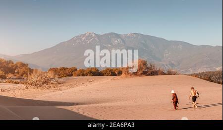 10. September 2020, Patara, Türkei: Touristen wandern bei Sonnenuntergang am Rande einer riesigen Sanddüne in Patara entlang. Natürliche Sehenswürdigkeiten in der Türkei Stockfoto