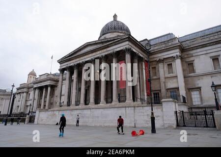 Mit sehr wenigen Menschen unterwegs ist die Szene am Trafalgar Square und die National Gallery ist eine der leeren Verwüstung, abgesehen von ein paar jungen Menschen Rollerblading und Rollerskating als die nationale Coronavirus Lockdown drei am 28th. Januar 2021 in London, Großbritannien fortgesetzt. Nach der Zunahme der Fälle im Winter, einschließlich einer neuen britischen Variante von Covid-19, rät diese landesweite Sperre allen Bürgern, der Botschaft zu folgen, zu Hause zu bleiben, den NHS zu schützen und Leben zu retten. Stockfoto