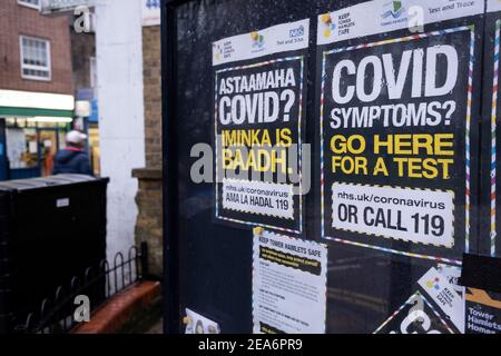 Covid-19 Testplakate in drei verschiedenen Sprachen wurden am 30th. Januar 2021 in London, Großbritannien, in der Community Noticeboard in Wapping, Tower Hamlets platziert. Die Poster in Somali, Englisch und Bangladeshi zeigen den Weg, um ein Coronavirus-Testzentrum zu finden, wenn Symptome auftreten. Stockfoto