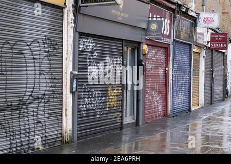 Bei geschlossenen Fensterläden werden alle Geschäfte entlang der Wentworth Street neben der berühmten Petticoat Lane geschlossen, einem Marktgebiet der City of London, das aufgrund der Coronavirus-Pandemie verlassen ist, da die nationale Sperre drei am 29th. Januar 2021 in London, Großbritannien, fortgesetzt wird. Nach der Zunahme der Fälle im Winter, einschließlich einer neuen britischen Variante von Covid-19, rät diese landesweite Sperre allen Bürgern, der Botschaft zu folgen, zu Hause zu bleiben, den NHS zu schützen und Leben zu retten. Stockfoto