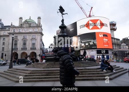 Am Piccadilly Circus zeigen die riesigen Werbebildschirme den Slogan, dass London stark bleiben soll, da die nationale Coronavirus-Sperre drei am 29th. Januar 2021 in London, Großbritannien, fortgesetzt wird. Nach der Zunahme der Fälle im Winter, einschließlich einer neuen britischen Variante von Covid-19, rät diese landesweite Sperre allen Bürgern, der Botschaft zu folgen, zu Hause zu bleiben, den NHS zu schützen und Leben zu retten. Stockfoto