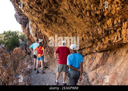 Wanderer, die San-Felskunst in Cedar Falls, Baviaanskloof, Südafrika, betrachten Stockfoto