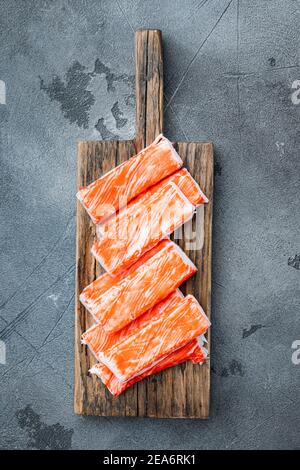 Fresh Crab Fleisch Stick surimi , auf Holz Schneidebrett, auf grauem Hintergrund, Draufsicht flach legen Stockfoto