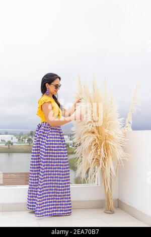 Nette lateinische Frau genießt die Anordnung ihrer Pampas Gras Blumenarrangement Stockfoto