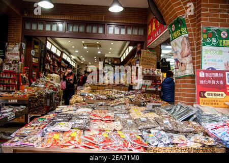 Taipeh, Taiwan. Februar 2021, 08th. Straßenhändler bieten saisonales Mondneujahr-Kleinartikel an, darunter Nüsse, getrocknete Früchte und Fleisch-Jerky. Taipei's Lunar New Year Market auf Dihua Street wird wegen Bedenken über COVID-19 abgesagt. Kredit: SOPA Images Limited/Alamy Live Nachrichten Stockfoto
