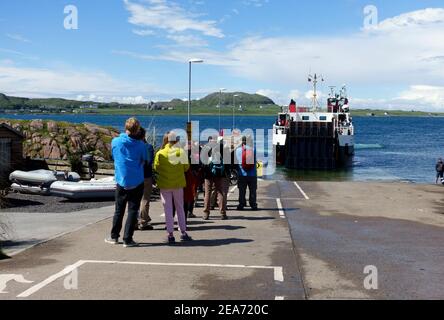 Besucher von Iona, die sich für die Calmac-Fähre in Fionnphort, Isle of Mull, anstellen Stockfoto
