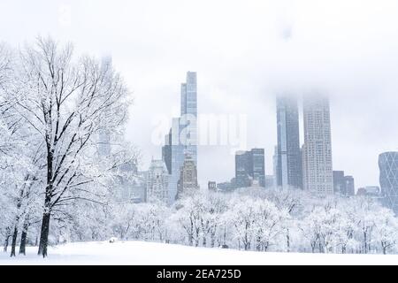 Wunderschöne Aussicht auf die Skyline von New York City von einem leeren Central Park während eines schweren Schneesturms. Stockfoto