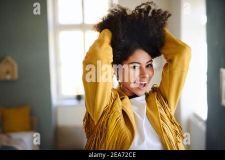 Porträt einer lachenden jungen Frau in Innenräumen, die auf die Kamera schaut. Stockfoto