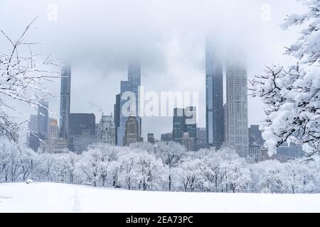 Leerer Central Park während eines wunderschönen Schneesturms mit Blick auf die Stadt. Stockfoto