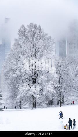 Menschen, die während eines Schneesturms im Central Park einen Schneemann bauen. Stockfoto