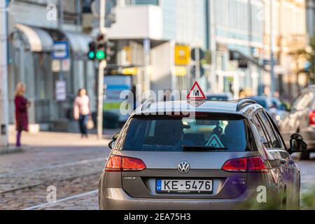 Riga, Lettland - 7. Oktober 2020: Auto mit lettischem Fahrschulschild auf dem Dach, verschwommene Straße mit Ampel im Hintergrund Stockfoto