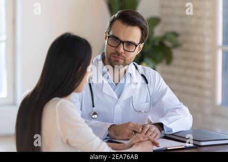 Männlicher Arzt hört auf weibliche Patienten klagt Stockfoto