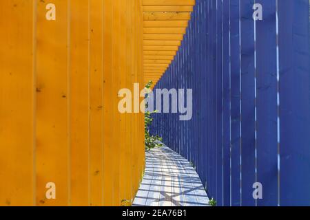 Bunte Holzpassage, City Decoraction. Gemalt in hellblauen und gelben Farben. Stockfoto