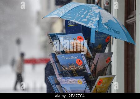 Berlin, Deutschland. Februar 2021, 08th. In einer Buchhandlung in der Bölschestraße Friedrichshagen gibt es einen Stand mit Büchern und Kalendern, die durch einen Regenschirm vor dem Schnee geschützt sind. Quelle: Kira Hofmann/dpa-Zentralbild/dpa/Alamy Live News Stockfoto