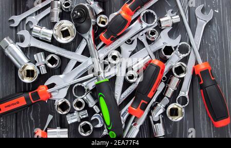 Hintergrund von Schraubendrehern und Schraubenschlüsseln, die chaotisch auf einem Grau liegen Holztisch Stockfoto