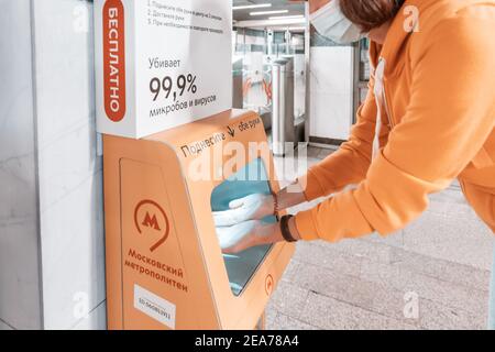 02. September 2020, Moskau, Russland: Eine Passagierin desinfiziert und wäscht ihre Hände in einem speziellen Gerät mit einem Desinfektionsmittel in der Moskauer U-Bahn. Stockfoto