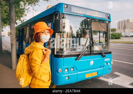 02. September 2020, Moskau, Russland: Glückliche asiatische Frau mit Schutzmaske Reisen mit Bus und Moskauer öffentlichen Verkehrsmitteln Stockfoto